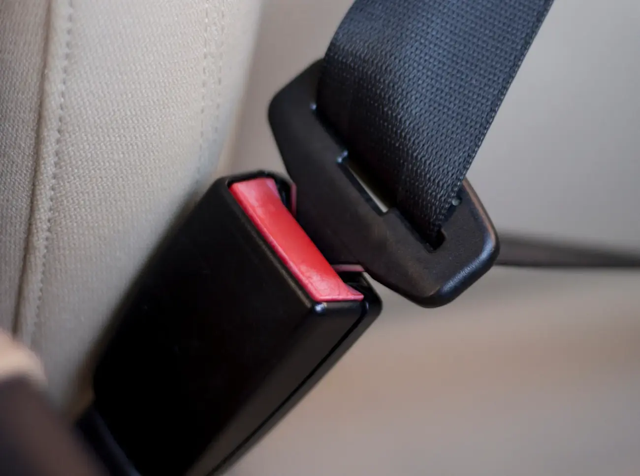 Seat belt tongue plate aligned with its buckle housing inside a vehicle interior