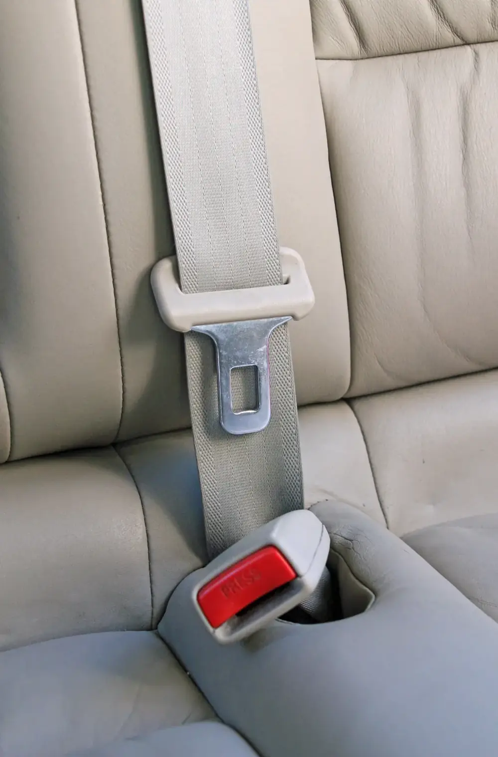 Seat belt running through an upper adjuster loop down to the latch plate and buckle in a vehicle